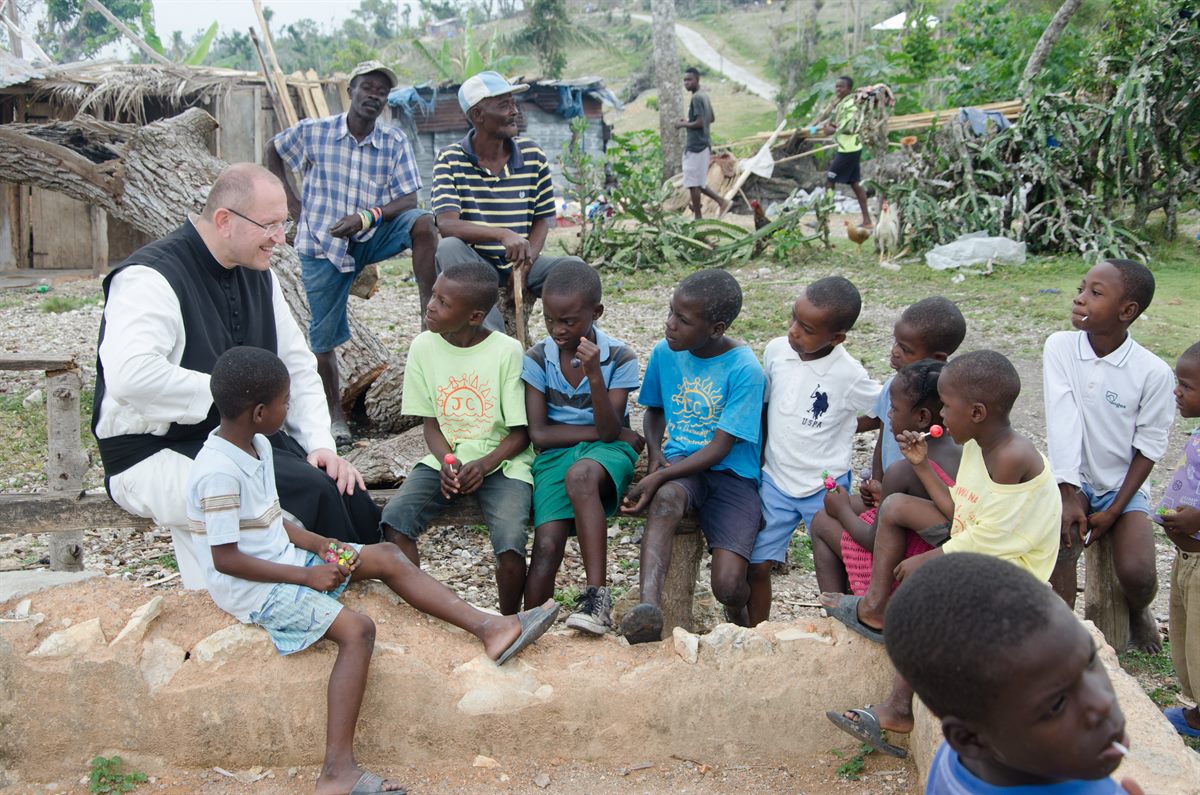 Pater Karl Wallner spricht mit Kindern auf Haiti