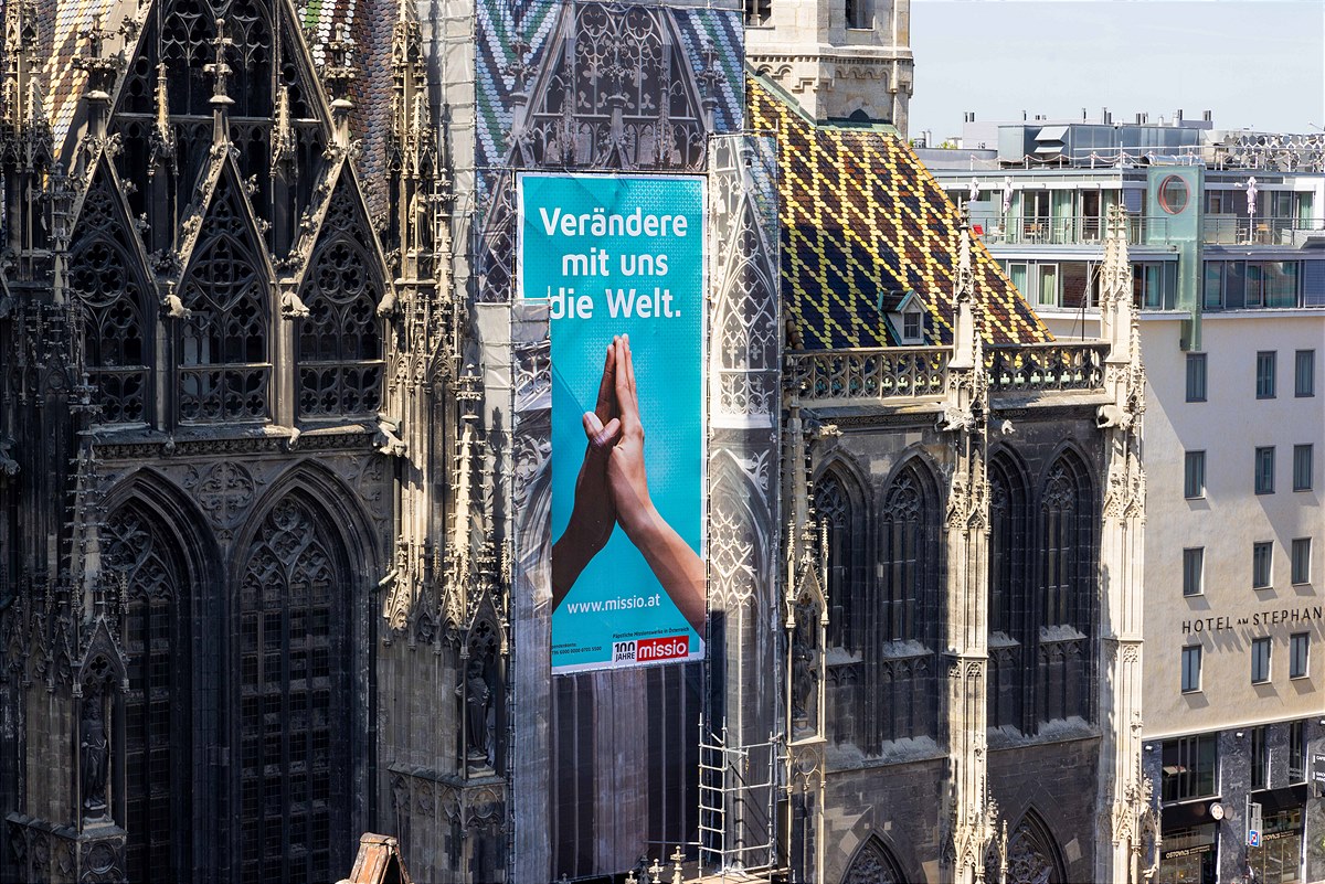 Plakatkampagne Verändere mit uns die Welt am Nordturm des Wiener Stephansdoms
