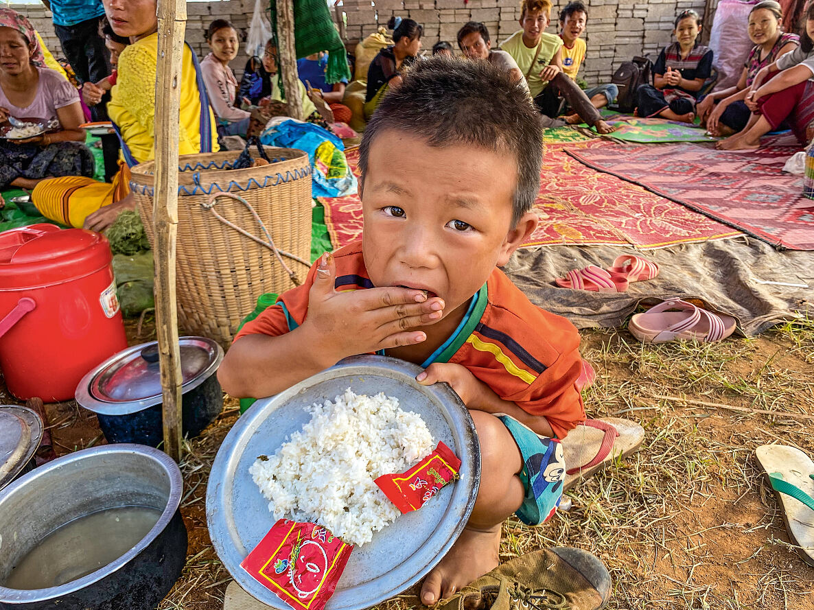 Vertriebene Familien mit Kindern erhalten im Dschungel von Myanmar Lebensmitteln von den Salesianern Don Boscos 